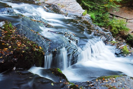 Waterfall over rocks in mountain in Autumn. From Pennsylvania Dingmans Falls.の写真素材