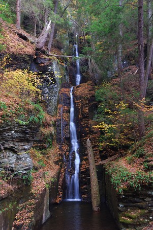 Autumn Waterfall in mountain with foliage and woods over rocks. Silver Thread Falls from Bushkill Falls.の写真素材
