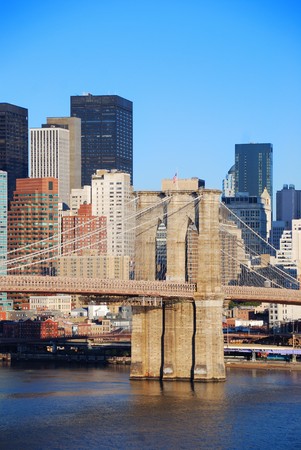 New York City Manhattan skyline with Brooklyn Bridge and skyscrapers over Hudson River in the morning after sunrise.の写真素材