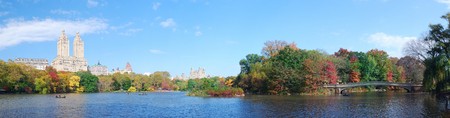 New York City Central Park panorama view in Autumn with Manhattan skyscrapers and colorful trees with Rainbow Bridge over lake with reflection.の写真素材