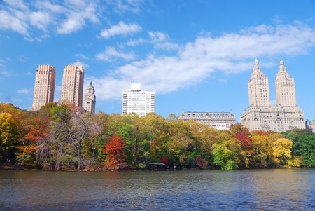 New York City Central Park in Autumn with Manhattan skyscrapers and colorful trees over lake with reflection.の写真素材