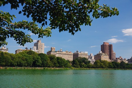 New York City Central Park urban Manhattan skyline with skyscrapers and trees lake reflection with blue sky and white cloud.の写真素材