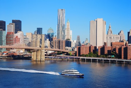 New York City Manhattan skyline with Brooklyn Bridge and skyscrapers over Hudson River in the morning after sunrise.の写真素材