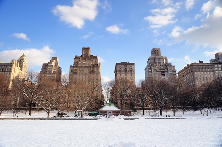 New York City Manhattan Central Park in winter with snow and city skyline with skyscrapers, blue cloudy sky.の写真素材