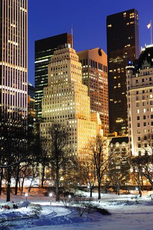 New York City Manhattan Central Park panorama in winter with snow, freezing lake and skyscrapers at dusk.の写真素材