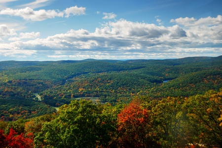 Autumn Mountain peak view panorama with colorful foliage in forest and rocks with cloudy sky.の写真素材