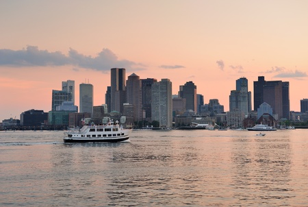 Boston downtown sunset skyline over river with skyscrapers and boat.の写真素材