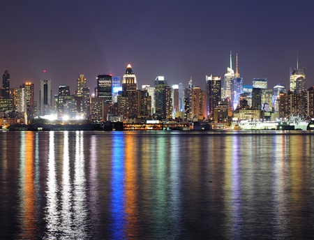 New York City Manhattan midtown skyline at night with lights reflection over Hudson River viewed from New Jersey Weehawken waterfront.の写真素材