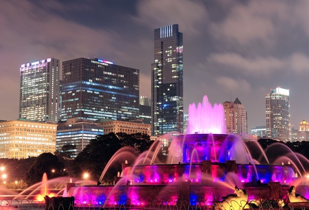 Chicago skyline with skyscrapers and Buckingham fountain in Grant Park at night lit by colorful lights.の写真素材