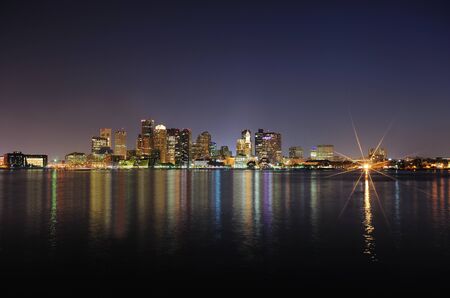 Boston downtown with urban city skyline at night with skyscrapers illuminated over sea.のeditorial素材