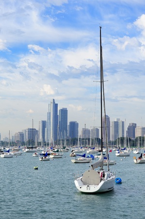 Chicago city downtown urban skyline with skyscrapers over Lake Michigan with cloudy blue sky and boat in the morning.のeditorial素材