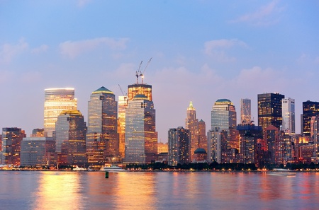 New York City Manhattan downtown skyline at dusk with skyscrapers illuminated over Hudson River panoramaの写真素材