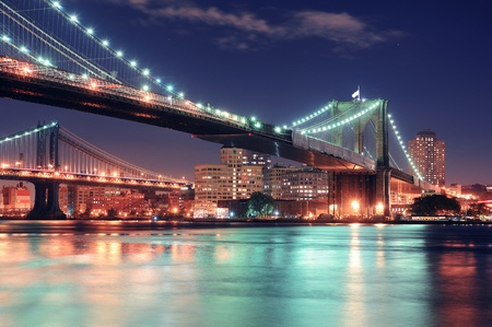 Brooklyn Bridge over East River at night in New York City Manhattan with lights and reflections.の写真素材
