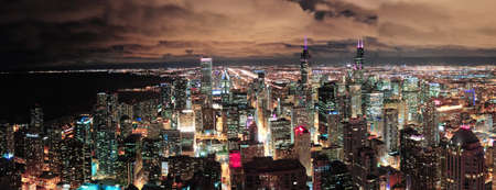 Chicago urban skyline panorama aerial view with skyscrapers and cloudy sky at dusk with lights.の写真素材