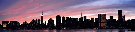 New York City Manhattan midtown silhouette panorama at sunset with skyscrapers and colorful sky over...