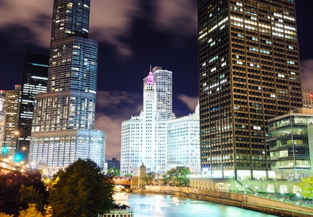 Chicago River Walk with urban skyscrapers illuminated with lights and water reflection at night. の写真素材