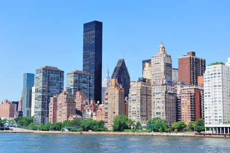 Manhattan midtown skyline panorama over East River with urban skyscrapers and blue sky in New York Cityの写真素材