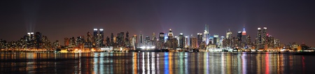 New York City Manhattan midtown skyline at night with lights reflection over Hudson River viewed from New Jersey Weehawken waterfront.の写真素材