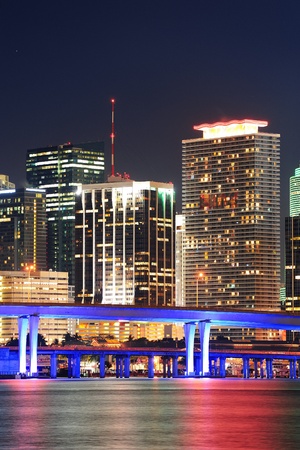 Miami city skyline closeup at dusk with urban skyscrapers and bridge over sea with reflectionの写真素材