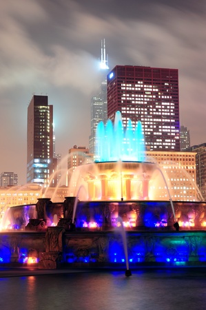 Chicago skyline with skyscrapers and Buckingham fountain in Grant Park at night lit by colorful lights.のeditorial素材