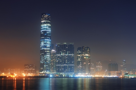 Hong Kong city skyline at night over Victoria Harbor with clear sky and urban skyscrapers.の写真素材
