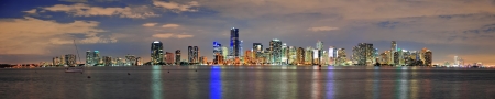 Miami city skyline panorama at dusk with urban skyscrapers over sea with reflectionの写真素材