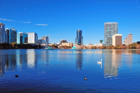Orlando Lake Eola in the morning with urban skyscrapers and clear blue sky with swan の写真素材