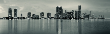 Miami city skyline panorama at dusk with urban skyscrapers over sea with reflectionの写真素材