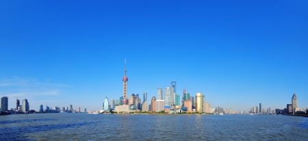 Shanghai skyline panorama with skyscrapers and blue clear sky over Huangpu River.