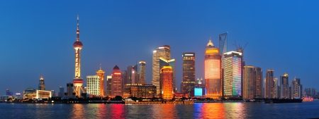Urban skyscrapers in Shanghai at night over riverの写真素材