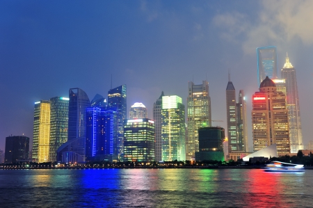 Urban skyscrapers in Shanghai at night over riverの写真素材