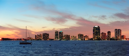 Miami city skyline panorama at dusk with urban skyscrapers over sea with reflectionの写真素材
