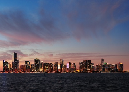 Miami city skyline panorama at dusk with urban skyscrapers over sea with reflectionの写真素材