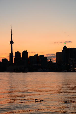 Toronto city skyline silhouette at sunset over lake with urban skyscrapers の写真素材