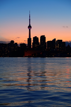 Toronto city skyline silhouette at sunset over lake with urban skyscrapers.の写真素材