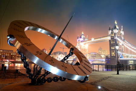Sundial and Tower Bridge at waterfront in Londonの写真素材