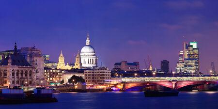 London skyline at night with bridge and St Pauls Cathedral over Thames River.の写真素材