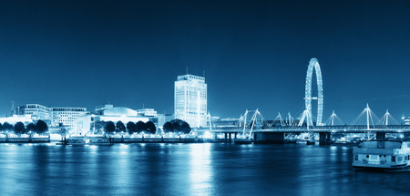 Thames River night view with office buildings, boat and London eye in black and white のeditorial素材