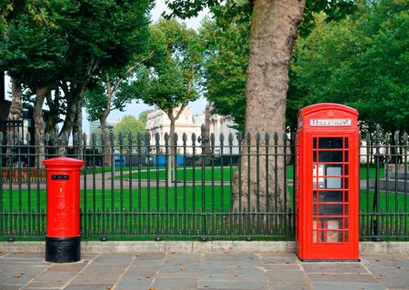 Red telephone and post box in street with historical architecture in London.の写真素材