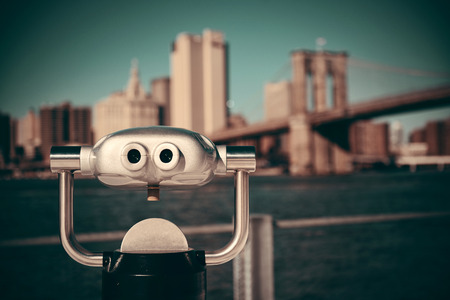 Binocular at waterfront with Brooklyn Bridge and skyscrapers.の写真素材