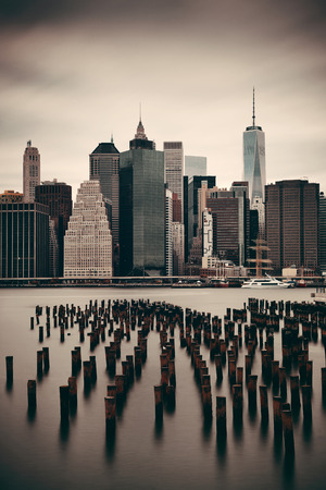 Manhattan financial district with skyscrapers and abandoned pier over East River.の写真素材
