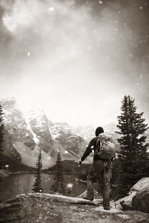 Hiker in Moraine Lake with snow capped mountain of Banff National Park in Canada in a snowing dayの写真素材