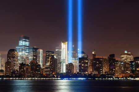 New York City downtown urban architecture at night and September 11 tribute lightの写真素材