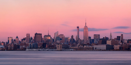 New York City midtown skyline with skyscrapers over Hudson River viewed from New Jersey at sunsetの写真素材