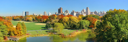 Lake and Autumn foliage with apartment buildings in Central Park of midtown Manhattan New York Cityの写真素材