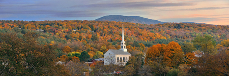 Stowe at sunset in Autumn with colorful foliage and community church in Vermontの写真素材