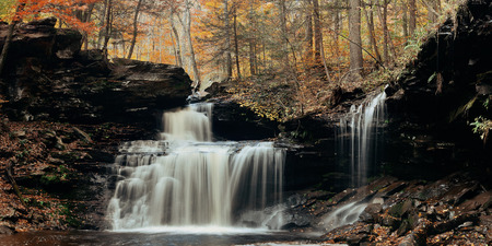 Autumn waterfalls panorama in park with colorful foliage.の写真素材