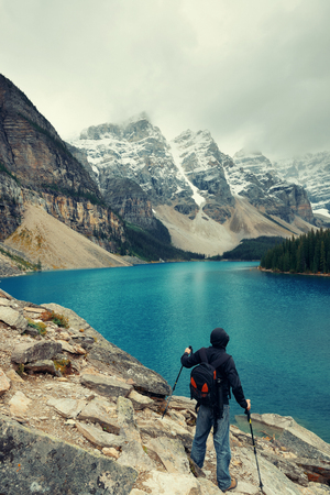 Hiker in Moraine Lake with snow capped mountain of Banff National Park in Canadaの写真素材