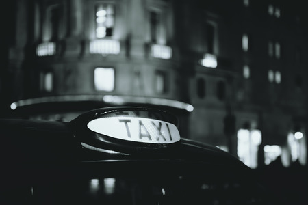Vintage taxi in street in London at night.の写真素材
