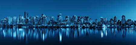 Vancouver downtown architecture and boat with water reflections at dusk panoramaの写真素材